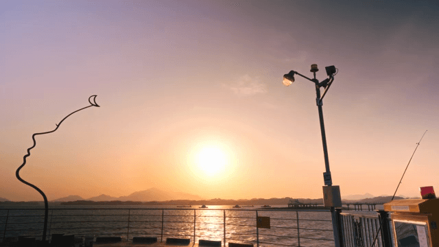 조각상과 함께 바다 위의 일몰 풍경