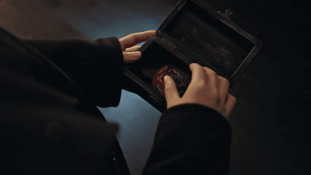 실내에서 머리 장식이 들어있는 상자를 들고 있는 사람