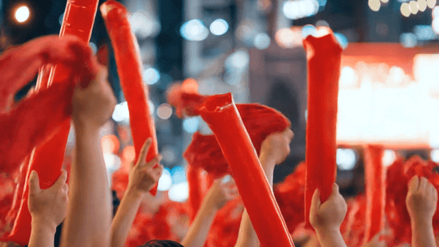 Lively crowd waving red cheering sticks