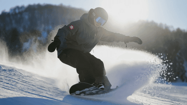 Snowboarder carving through fresh snow