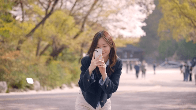 벚꽃이 핀 공원에서 사진을 찍어주는 여성