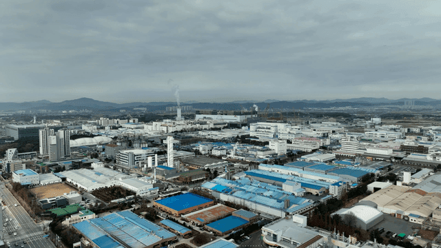 Urban industrial complex spread out under cloudy sky