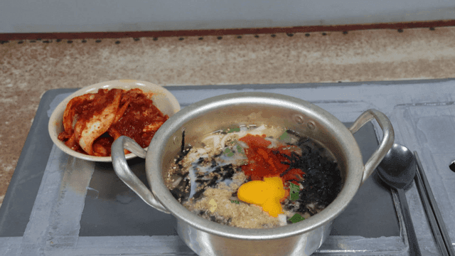 테이블 위의 김치와 계란 닭칼국수