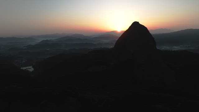 새벽녘 동이 트는 하늘과 웅장한 산봉우리의 실루엣