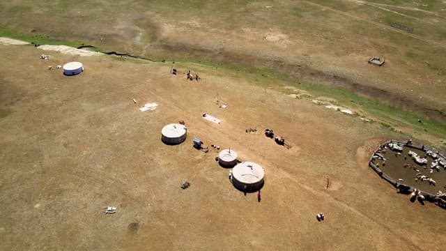 Landscape with yurts and livestock