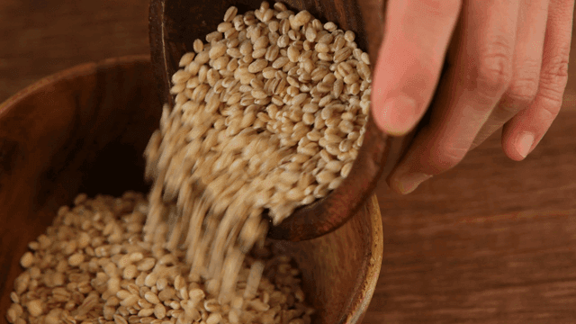 Pouring grains into a wooden bowl