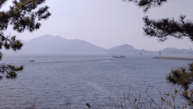 Boats sailing on a calm sea with mountains