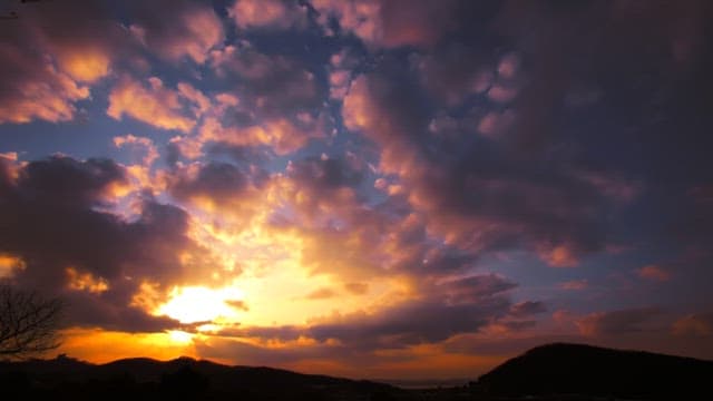 산 위로 펼쳐진 화려한 구름과 일몰