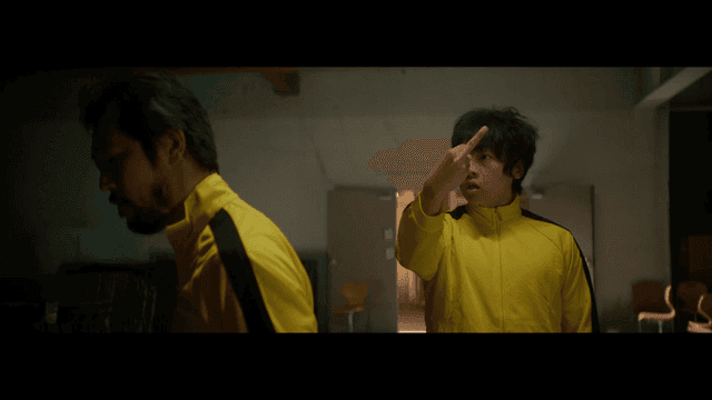 노란 트레이닝복을 입고 손가락 욕을 하는 남자