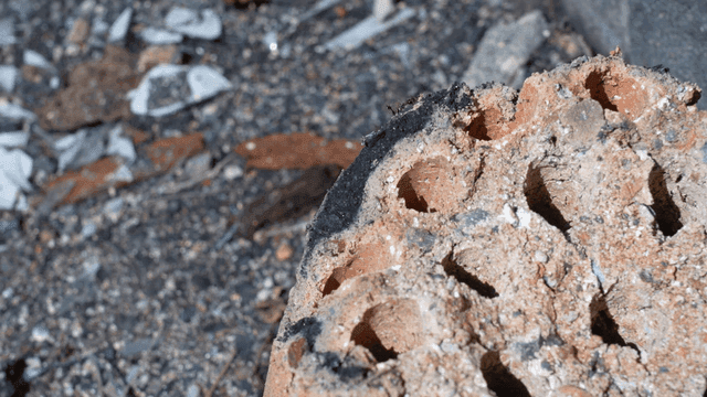 Close-up of a weathered brick on the ground