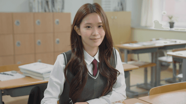 Female student smiling while sitting in the classroom