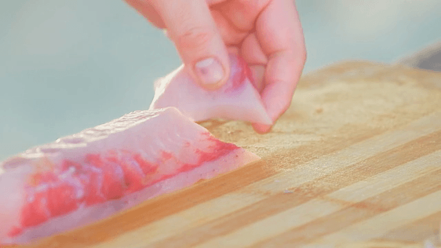 Slicing fresh fish on a wooden board