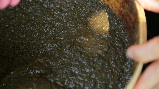 Stirring seaweed jelly batter with a wooden spatula in a bowl