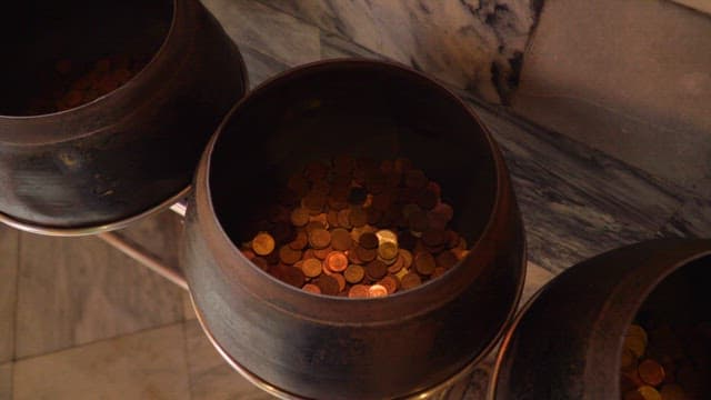 Donation pots filled with coins in a temple