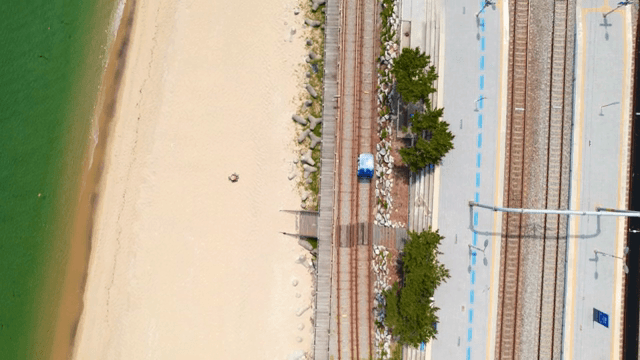 Train tracks by the beach with clear water