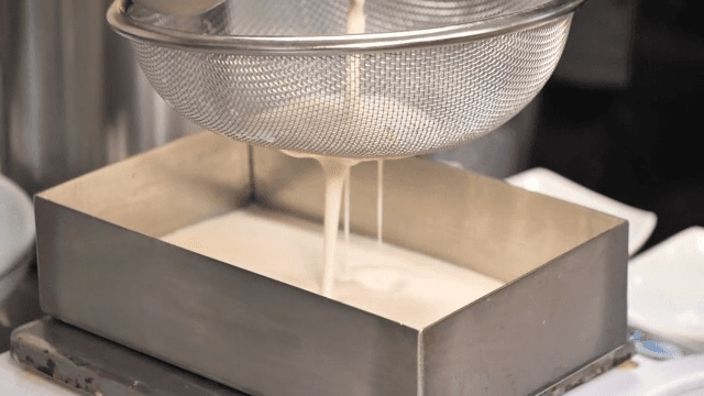 콩물이 금속 용기에 걸러지는 모습