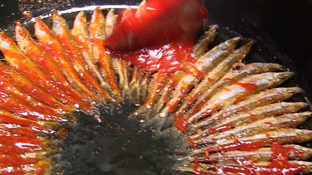 양념을 바르고 깨를 뿌리는 도리뱅뱅이