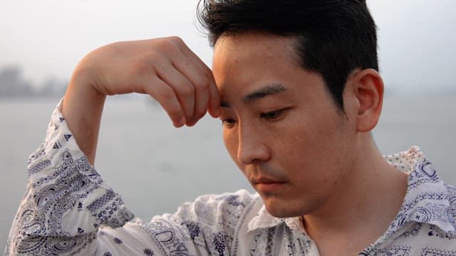 생각에 잠긴 채 바다를 바라보는 남자