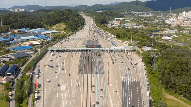 Busy highway tollgate surrounded by greenery