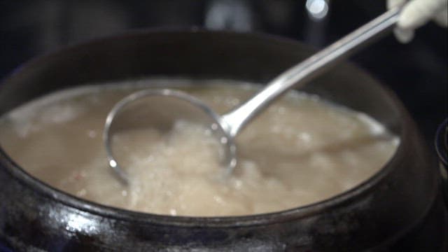 푹 끓인 사골육수를 그릇에 담는 장면