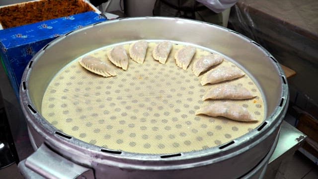 Preparing dumplings for steaming in a kitchen