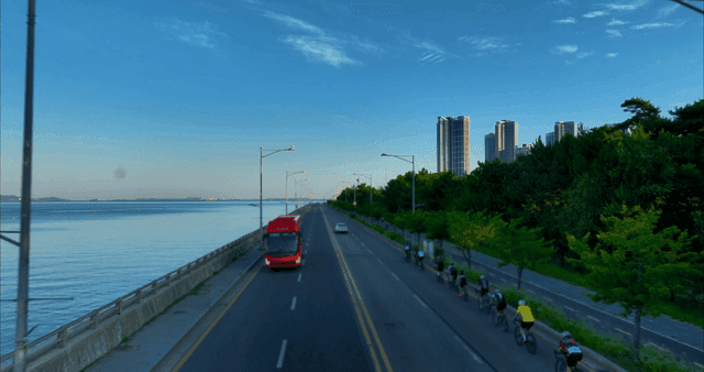 자전거 타는 사람들과 고층 건물이 있는 해안 도로