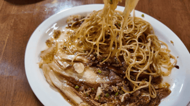 Fork used to twirl and roll up cabbage garlic pasta on plate