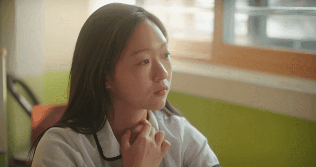 교실에서 책상을 보며 대화하는 여학생