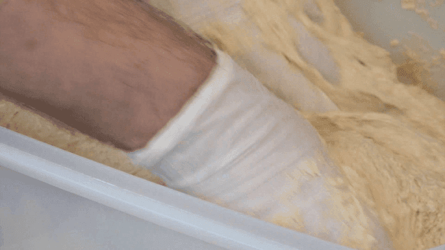 Kneading dough inside a bowl by baker's hands
