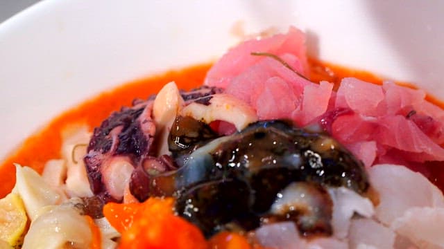 Fresh cold raw fish soup in a white bowl