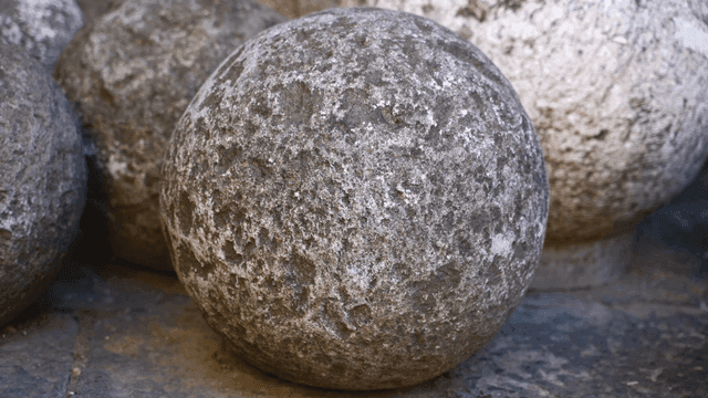 바닥에 놓인 거친 질감의 돌 구체