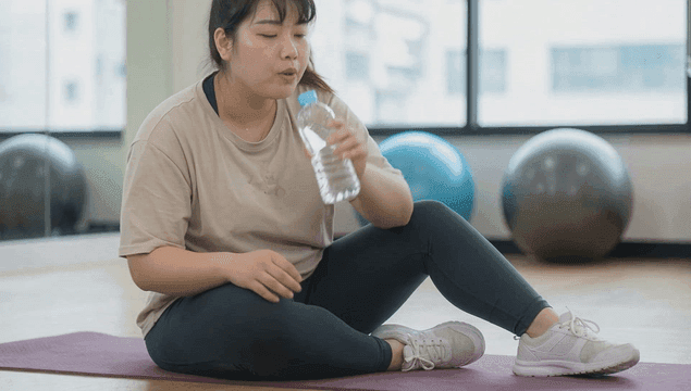 Obese woman resting after working out at gym
