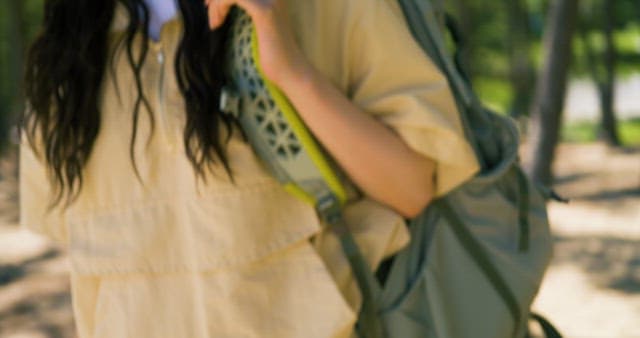 Person Putting Down a Backpack Under a Tree