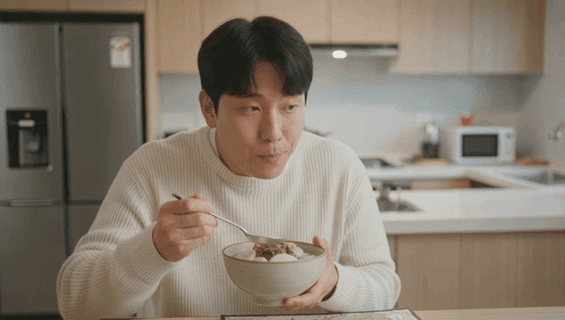 Man eating tteokguk in kitchen