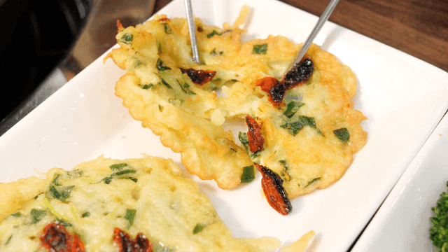 Chopsticks tearing potato pancake on plate