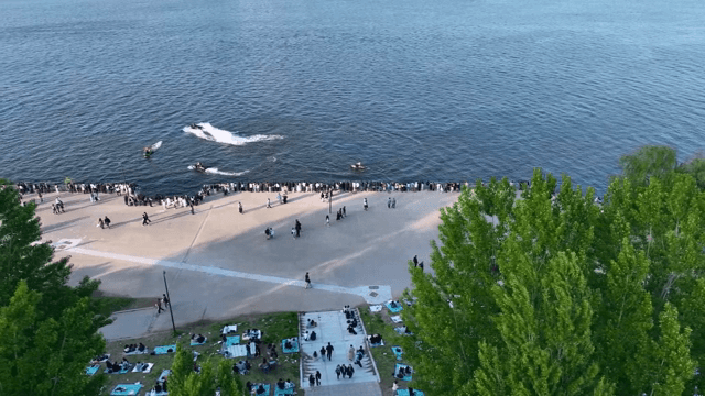 사람들이 제트스키와 함께 강변 공원을 즐기는 모습