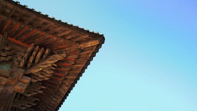 Eaves of a traditional temple house under a clear sky