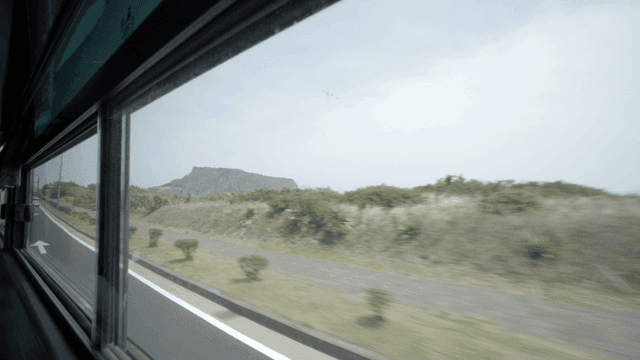 View of a coastal road from a moving bus