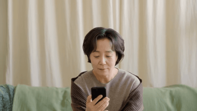 실내에서 스마트폰을 사용하는 여성