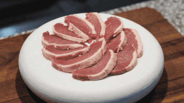 Slices of raw meat arranged on a plate