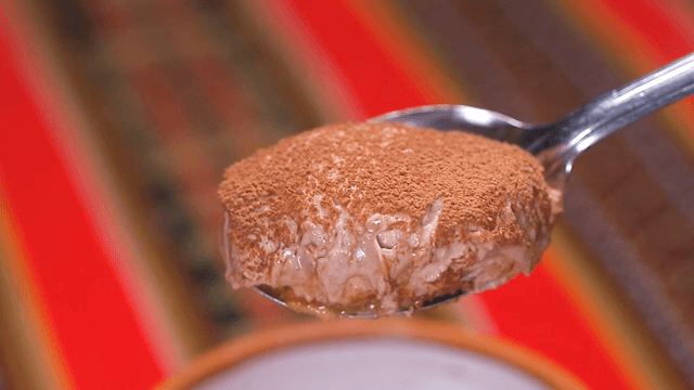 코코아가 뿌려진 크림 디저트 한 숟가락