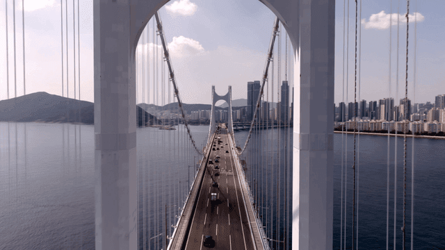 현대 도시 스카이라인으로 이어지는 바다 위 거대한 다리