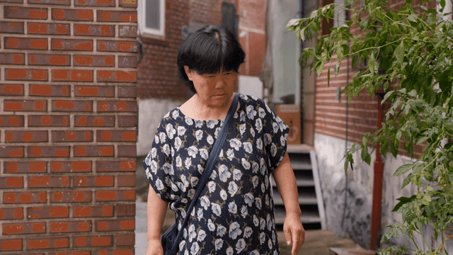 골목길을 걷는 노인 여성