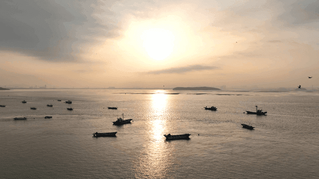 일출 시 고요한 바다의 배들