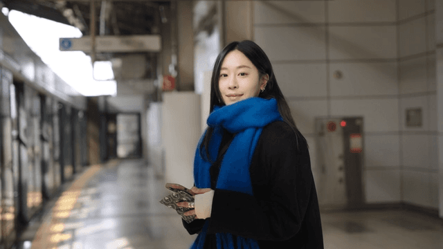 Woman smiling while waiting at a winter subway station