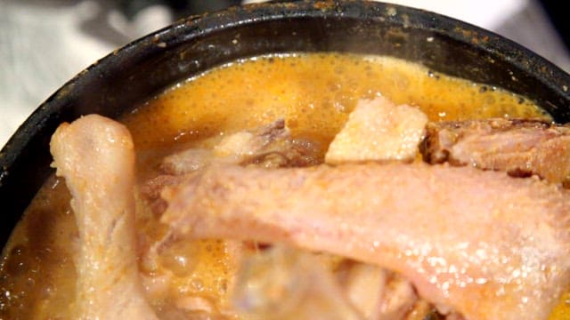 Duck soup boiling in an earthen pot