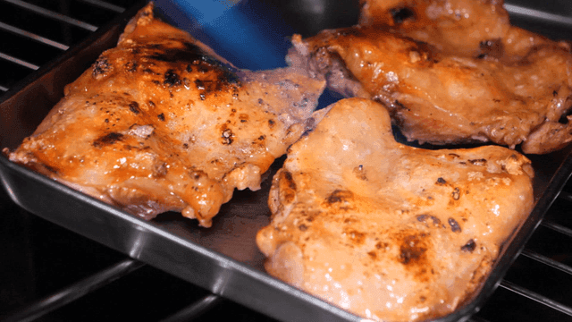 Grilled chicken being cooked in an oven