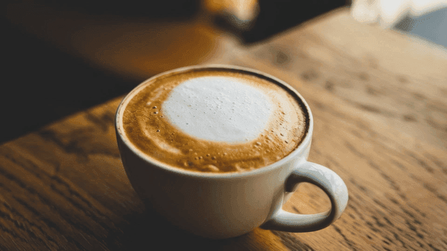 나무 테이블 위의 카푸치노 한 잔