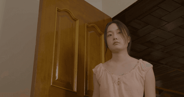 문간에 서 있다가 방 안으로 들어오는 여성