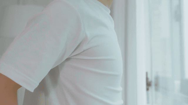 창문 너머를 바라보며 스트레칭하는 사람